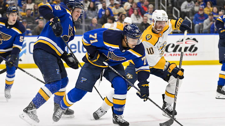 Mar 23, 2025; St. Louis, Missouri, USA;  St. Louis Blues right wing Mathieu Joseph (71) and Nashville Predators center Colton Sissons (10) b battle for the puck during the third period at Enterprise Center. Mandatory Credit: Jeff Curry-Imagn Images