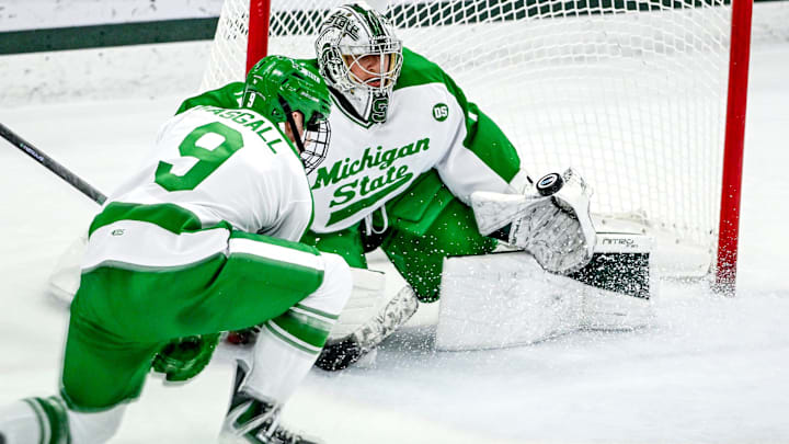 Michigan State's Trey Augustine, right, deflects a Notre Dame shot during the first period on Thursday, Feb. 19, 2026, at the Munn Ice Arena in East Lansing.