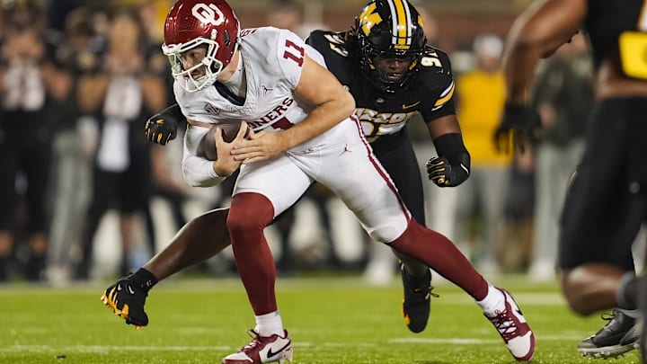 Nov 9, 2024; Columbia, Missouri, USA; Oklahoma Sooners quarterback Jackson Arnold (11) runs the ball against Missouri Tigers defensive end Eddie Kelly Jr. (97) during the first half at Faurot Field at Memorial Stadium. Mandatory Credit: Jay Biggerstaff-Imagn Images