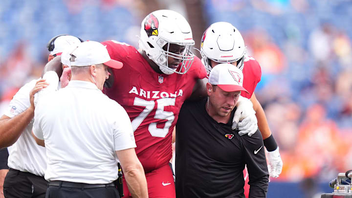 Aug 25, 2024; Denver, Colorado, USA; Arizona Cardinals offensive tackle Christian Jones (75) is helped towards a cart in the second half against the Arizona Cardinals at Empower Field at Mile High. Mandatory Credit: Ron Chenoy-Imagn Images Aug 25, 2024; Denver, Colorado, USA; Arizona Cardinals offensive tackle Christian Jones (75) is helped towards a cart in the second half against the Arizona Cardinals at Empower Field at Mile High. Mandatory Credit: Ron Chenoy-Imagn Images