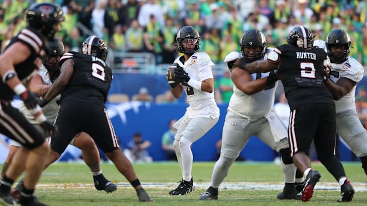 Jan 1, 2026; Miami Gardens, FL, USA; Oregon Ducks quarterback Dante Moore (5) stands in the pocket against the Texas Tech Red Raiders during the second half of the 2025 Orange Bowl and quarterfinal game of the College Football Playoff at Hard Rock Stadium. Mandatory Credit: Nathan Ray Seebeck-Imagn Images