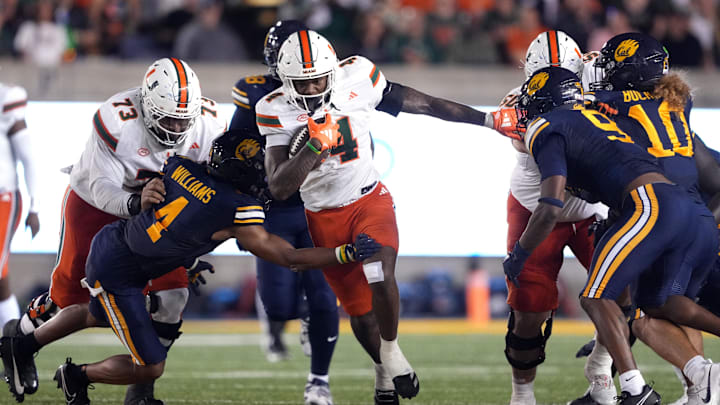 Oct 5, 2024; Berkeley, California, USA; Miami Hurricanes running back Mark Fletcher Jr. (center) carries the ball against California Golden Bears defensive back Miles Williams (center left) during the second quarter at California Memorial Stadium. Mandatory Credit: Darren Yamashita-Imagn Images