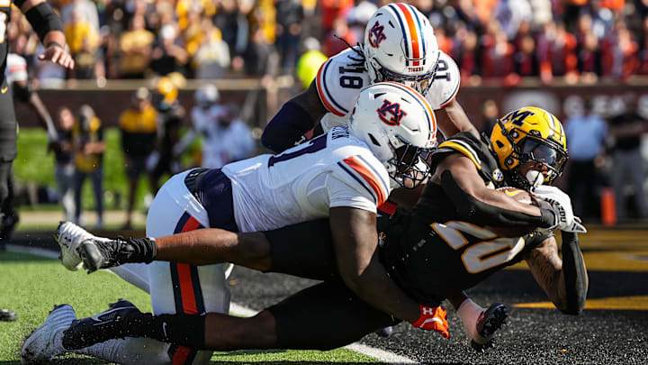 Oct 19, 2024; Columbia, Missouri, USA; Missouri Tigers running back Jamal Roberts (20) scores a touchdown against Auburn Tigers cornerback Mac McClinton (27) and safety Kaleb Harris (18) during the second half at Faurot Field at Memorial Stadium. Mandatory Credit: Jay Biggerstaff-Imagn Images