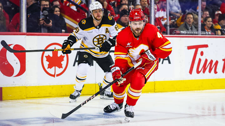 Dec 17, 2024; Calgary, Alberta, CAN; Calgary Flames defenseman Rasmus Andersson (4) controls the puck against the Boston Bruins during the first period at Scotiabank Saddledome. Mandatory Credit: Sergei Belski-Imagn Images