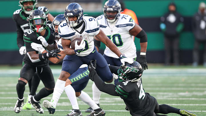 Dec 1, 2024; East Rutherford, New Jersey, USA; Seattle Seahawks running back Kenneth Walker III (9) is tackled by New York Jets cornerback D.J. Reed (4) during the second half at MetLife Stadium. 