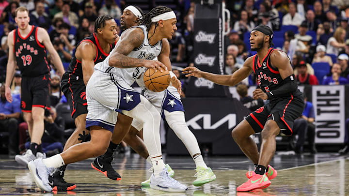 Toronto Raptors guard Immanuel Quickley (5) defends Orlando Magic forward Paolo Banchero (5) during the second half at Kia Center.