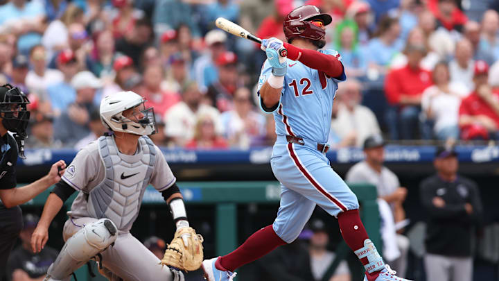 Apr 3, 2025; Philadelphia, Pennsylvania, USA; Philadelphia Phillies designated hitter Kyle Schwarber (12) hits a home run in front of Colorado Rockies catcher Jacob Stallings (25) during the seventh inning at Citizens Bank Park.