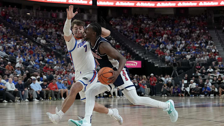 Nov 3, 2025; Las Vegas, NV, USA; Arizona Wildcats guard Jaden Bradley (0) drives against Florida Gators guard Urban Klavzar (7) in the second half of the Hall of Fame Series game at T-Mobile Arena. Mandatory Credit: Candice Ward-Imagn Images