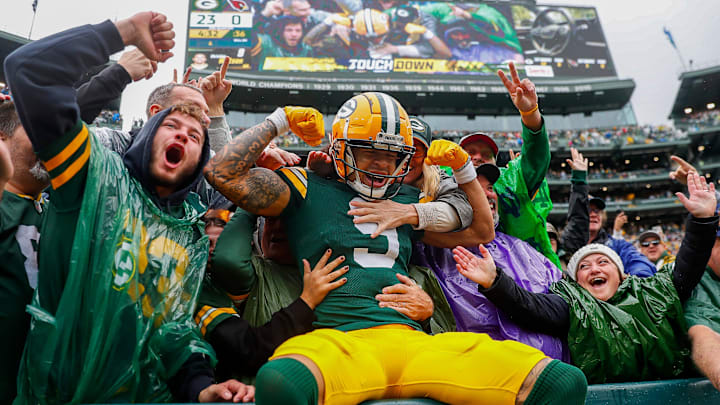 Green Bay Packers wide receiver Christian Watson (9) flexes as he does a Lambeau Leap after scoring against the Cardinals on Sunday.