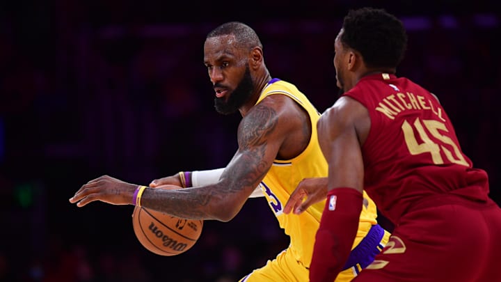 Dec 31, 2024; Los Angeles, California, USA; Los Angeles Lakers forward LeBron James (23) moves the ball against Cleveland Cavaliers guard Donovan Mitchell (45) during the first half at Crypto.com Arena. Mandatory Credit: Gary A. Vasquez-Imagn Images