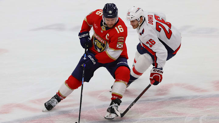 Nov 25, 2024; Sunrise, Florida, USA; Florida Panthers center Aleksander Barkov (16) moves the puck ahed of Washington Capitals center Nic Dowd (26) during the third period at Amerant Bank Arena. Mandatory Credit: Sam Navarro-Imagn Images