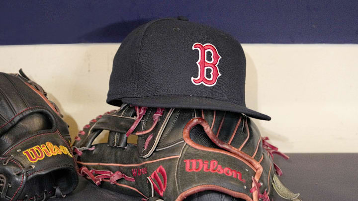 May 27, 2025; Milwaukee, Wisconsin, USA; A Boston Red Sox hat and glove sit in the dug out before a game against the Milwaukee Brewers at American Family Field. Mandatory Credit: Michael McLoone-Imagn Images