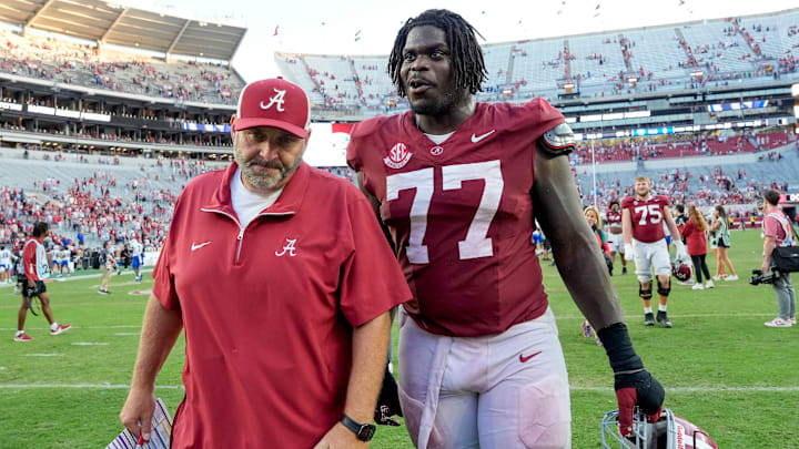Nov 22, 2025; Tuscaloosa, Alabama, USA; Offensive line coach Chris Kapilovic walks of the field with Alabama senior offensive lineman Jaeden Roberts (77) at Saban Field at Bryant-Denny Stadium. Mandatory Credit: Gary Cosby Jr.-Imagn Images