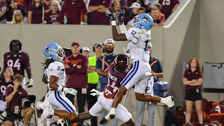 Sep 13, 2025; Blacksburg, Virginia, USA;  Old Dominion Monarchs safety Jerome Carter (12) goes for an interception for a pass intended for Virginia Tech Hokies wide receiver Isaiah Spencer (14) during the second quarter at Lane Stadium. Mandatory Credit: Brian Bishop-Imagn Images