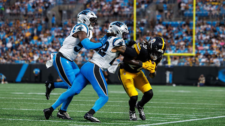 Aug 21, 2025; Charlotte, North Carolina, USA; Pittsburgh Steelers running back Kaleb Johnson (20) runs the ball as Carolina Panthers safety Lathan Ransom (22) and linebacker Bam Martin-Scott (57) attempt to block him during the 2nd quarter at Bank of America Stadium. 