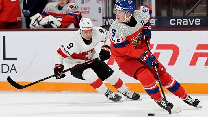 Jan 2, 2026; Minneapolis, Minnesota, USA; Czechia defensemen Adam Jiricek (5) controls the puck as Switzerland forward Nolan Cattin (9) gives chase during the first period in the quarterfinals of the 2026 IIHF World Junior Championship at 3M Arena. Mandatory Credit: Nick Wosika-Imagn Images