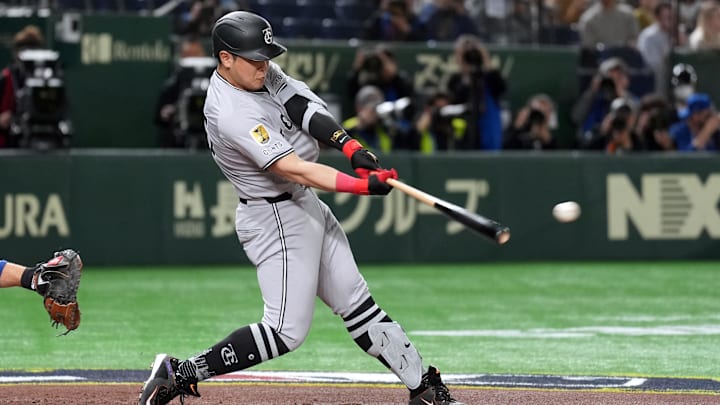 Mar 16, 2025; Bunkyo, Tokyo, Japan; Yomiuri Giants first baseman Kazuma Okamoto (25) hits a single against the Chicago Cubs during the second inning at Tokyo Dome. Mandatory Credit: Darren Yamashita-Imagn Images