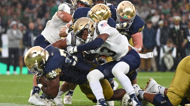 Aug 26, 2023; Dublin, IRL; Notre Dame Fighting Irish running back Audric Estime (7) scores a touchdown as Navy Midshipmen cornerback Elias Larry (3) defends in the first quarter at Aviva Stadium. Mandatory Credit: Matt Cashore-USA TODAY Sports Aug 26, 2023; Dublin, IRL; Notre Dame Fighting Irish running back Audric Estime (7) scores a touchdown as Navy Midshipmen cornerback Elias Larry (3) defends in the first quarter at Aviva Stadium. Mandatory Credit: Matt Cashore-USA TODAY Sports