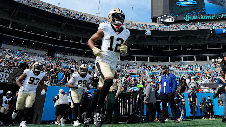 Nov 3, 2024; Charlotte, North Carolina, USA; New Orleans Saints wide receiver Chris Olave (12) runs on to the field before the game at Bank of America Stadium. Mandatory Credit: Bob Donnan-Imagn Images