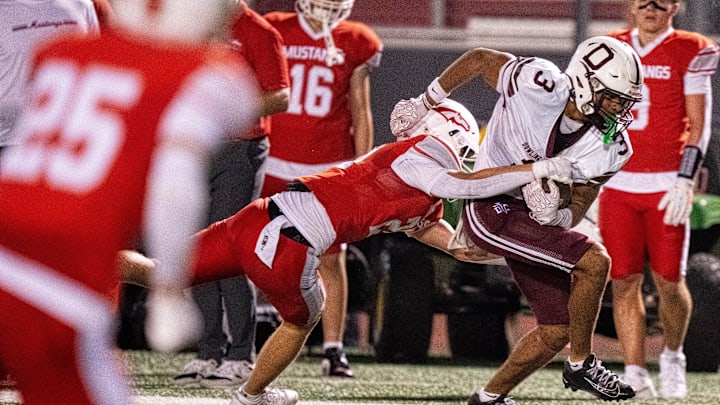 Dowling Catholic’s Jeffrey Roberts (3) sheds his DCG defender, DCG's Owen Jensen (21), on his way to the end zone for a touchdown on Sept. 12, 2025, at Dallas Center-Grimes High School.