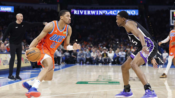 Feb 1, 2025; Oklahoma City, Oklahoma, USA; Oklahoma City Thunder guard Aaron Wiggins (21) drives to the basket against Sacramento Kings guard De'Aaron Fox (5) during the second half at Paycom Center. Mandatory Credit: Alonzo Adams-Imagn Images