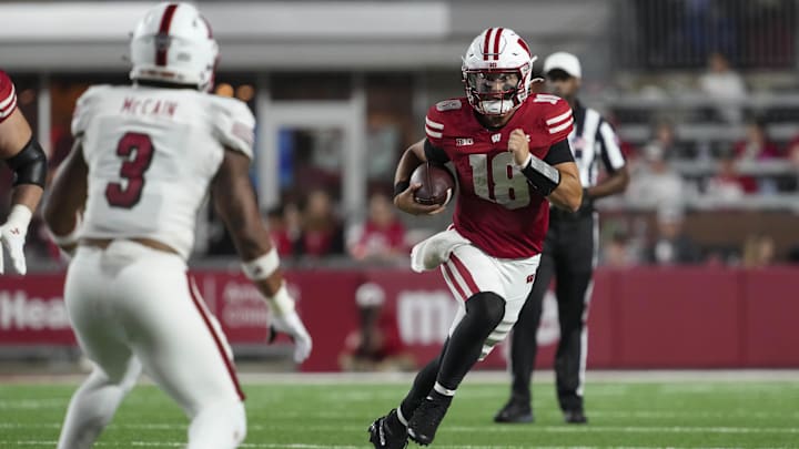 Aug 28, 2025; Madison, Wisconsin, USA;  Wisconsin Badgers quarterback Danny O'Neil (18) rushes with the football as Miami (OH) RedHawks linebacker Malcolm McCain (3) defends during the third quarter at Camp Randall Stadium. Mandatory Credit: Jeff Hanisch-Imagn Images