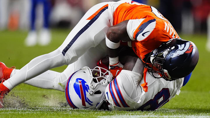 Denver Broncos cornerback Ja'quan McMillian (29) intercepts a pass intended for Buffalo Bills wide receiver Brandin Cooks (18) during overtime of an AFC Divisional Round playoff game at Empower Field at Mile High. 