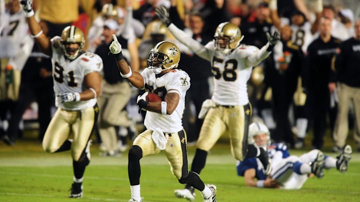 Feb 7, 2010; Miami, FL, USA; New Orleans Saints cornerback Tracy Porter (22) celebrates as he returns an interception for a touchdown as Indianapolis Colts quarterback Peyton Manning looks on from the ground during the fourth quarter of Super Bowl XLIV at Sun Life Stadium. Mandatory Credit: Mark J. Rebilas-Imagn Images