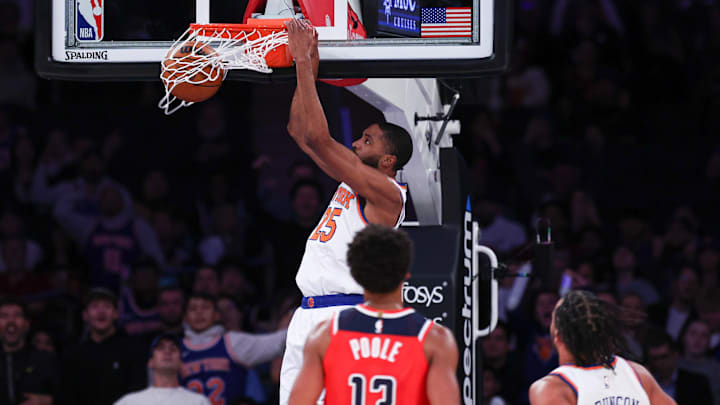 Oct 9, 2024; New York, New York, USA; New York Knicks forward Mikal Bridges (25) dunks the ball in front of Washington Wizards guard Jordan Poole (13) during the first quarter at Madison Square Garden. Mandatory Credit: Vincent Carchietta-Imagn Images