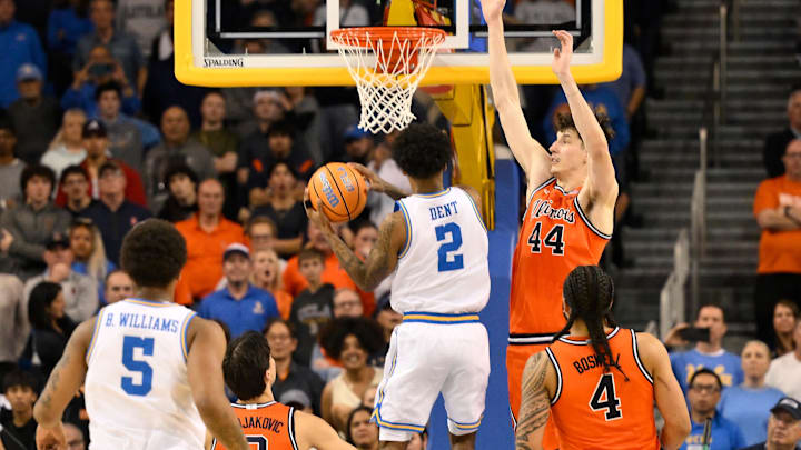 Feb 21, 2026; Los Angeles, California, USA; UCLA guard Donovan Dent (2) hangs in the air and scores the winning basket over Illinois center Zvonimir Ivisic (44) in overtime at Pauley Pavilion presented by Wescom Financial. Mandatory Credit: Robert Hanashiro-Imagn Images Feb 21, 2026; Los Angeles, California, USA; UCLA guard Donovan Dent (2) hangs in the air and scores the winning basket over Illinois center Zvonimir Ivisic (44) in overtime at Pauley Pavilion presented by Wescom Financial. Mandatory Credit: Robert Hanashiro-Imagn Images