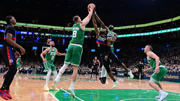 Dec 12, 2024; Boston, Massachusetts, USA;  Boston Celtics guard Jaylen Brown (7) and center Kristaps Porzingis (8) team up to defend against Detroit Pistons guard Malik Beasley (5) during the first half at TD Garden. Mandatory Credit: Eric Canha-Imagn Images