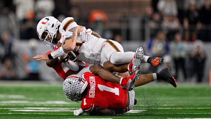 Dec 31, 2025; Arlington, TX, USA; Ohio State Buckeyes safety Leroy Roker III (28) and cornerback Davison Igbinosun (1) tackle Miami Hurricanes quarterback Carson Beck (11) during the 2025 Cotton Bowl and quarterfinal game of the College Football Playoff at AT&T Stadium. Mandatory Credit: Jerome Miron-Imagn Images Dec 31, 2025; Arlington, TX, USA; Ohio State Buckeyes safety Leroy Roker III (28) and cornerback Davison Igbinosun (1) tackle Miami Hurricanes quarterback Carson Beck (11) during the 2025 Cotton Bowl and quarterfinal game of the College Football Playoff at AT&T Stadium. Mandatory Credit: Jerome Miron-Imagn Images