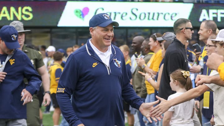 Sep 27, 2025; Morgantown, West Virginia, USA; West Virginia Mountaineers head coach Rich Rodriguez walks on the field and greets fans before their game against the Utah Utes at Milan Puskar Stadium. Mandatory Credit: Ben Queen-Imagn Images