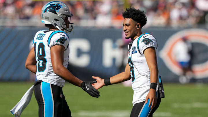 CHICAGO, ILLINOIS - OCTOBER 6: Quarterback Bryce Young #9 of the Carolina Panthers interacts with wide receiver Jalen Coker #18 on the field during the third quarter of an NFL football game against the Chicago Bears, at Soldier Field on October 6, 2024 in Chicago, Illinois.