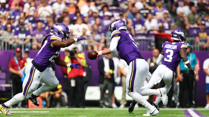 J.J. McCarthy hands the ball off to running back Jordan Mason. 