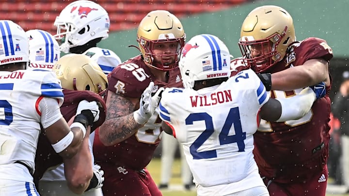 Dec 28, 2023; Boston, MA, USA; Boston College Eagles offensive lineman Logan Taylor (65) and offensive lineman Kevin Cline (79) team up on Southern Methodist Mustangs linebacker Kobe Wilson (24) during the second half at Fenway Park. Mandatory Credit: Eric Canha-Imagn Images Dec 28, 2023; Boston, MA, USA; Boston College Eagles offensive lineman Logan Taylor (65) and offensive lineman Kevin Cline (79) team up on Southern Methodist Mustangs linebacker Kobe Wilson (24) during the second half at Fenway Park. Mandatory Credit: Eric Canha-Imagn Images