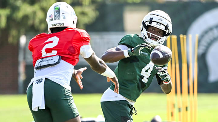 Michigan State running back Elijah Tau-Tolliver, right, gets a pitch from Aidan Chiles during football practice on Monday, Aug. 11, 2025, in East Lansing.