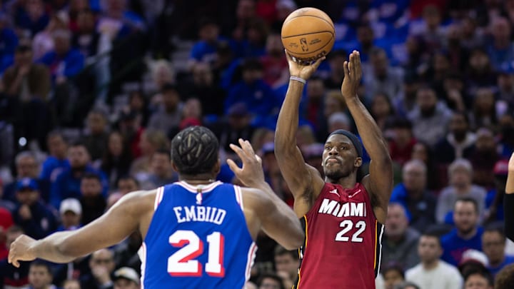 Apr 17, 2024; Philadelphia, Pennsylvania, USA; Miami Heat forward Jimmy Butler (22) shoots past Philadelphia 76ers center Joel Embiid (21) during the second quarter of a play-in game of the 2024 NBA playoffs at Wells Fargo Center. Mandatory Credit: Bill Streicher-Imagn Images