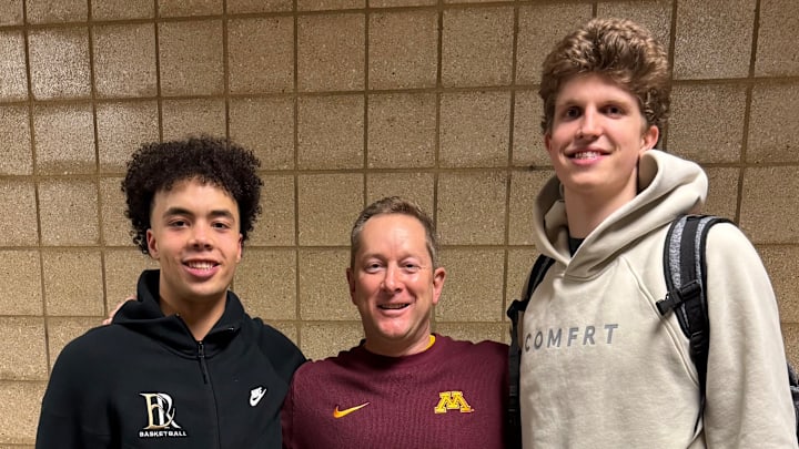Niko Medved with East Ridge guard Cedric Tomes (left) and Wayzata forward Nolen Anderson (right).