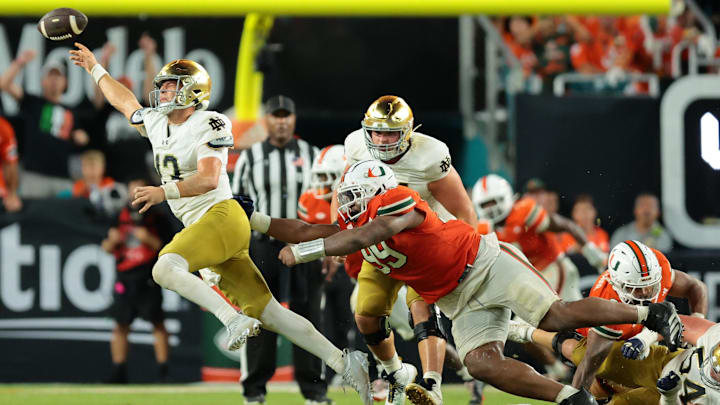 Aug 31, 2025; Miami Gardens, Florida, USA; Notre Dame Fighting Irish quarterback CJ Carr (13) throws the ball to avoid a sack against the Miami Hurricanes at Hard Rock Stadium. Mandatory Credit: Sam Navarro-Imagn Images Aug 31, 2025; Miami Gardens, Florida, USA; Notre Dame Fighting Irish quarterback CJ Carr (13) throws the ball to avoid a sack against the Miami Hurricanes at Hard Rock Stadium. Mandatory Credit: Sam Navarro-Imagn Images
