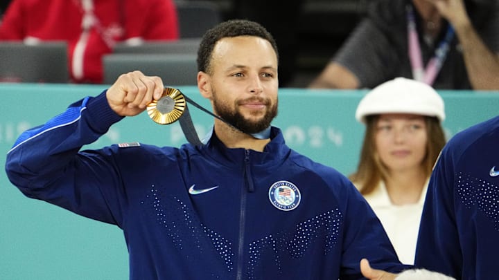 Aug 10, 2024; Paris, France; United States shooting guard Stephen Curry (4) celebrates with the gold medal after defeating France in the men's basketball gold medal game during the Paris 2024 Olympic Summer Games at Accor Arena. Mandatory Credit: Rob Schumacher-Imagn Images