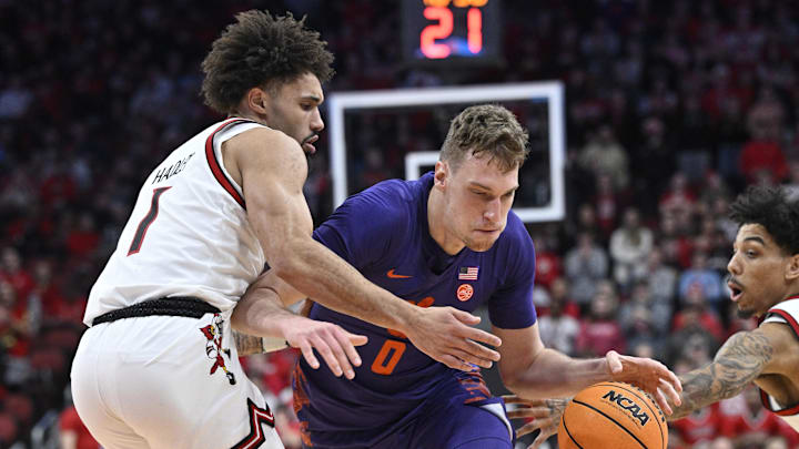 Jan 7, 2025; Louisville, Kentucky, USA; Clemson Tigers center Viktor Lakhin (0) drives to the basket against Louisville Cardinals guard J'Vonne Hadley (1) during the first half at KFC Yum! Center. Jan 7, 2025; Louisville, Kentucky, USA; Clemson Tigers center Viktor Lakhin (0) drives to the basket against Louisville Cardinals guard J'Vonne Hadley (1) during the first half at KFC Yum! Center.