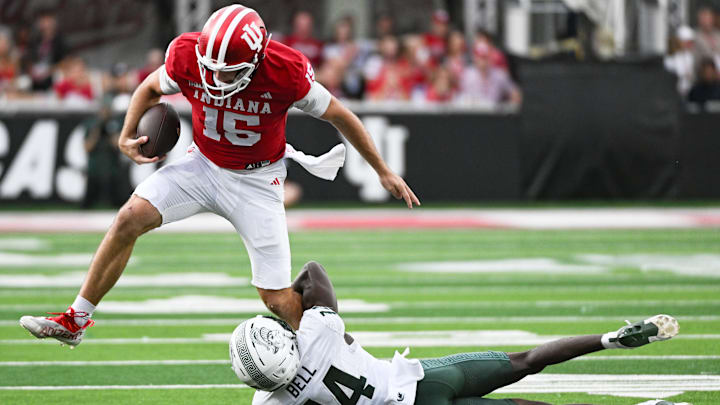 Oct 18, 2025; Bloomington, Indiana, USA; Indiana Hoosiers quarterback Fernando Mendoza (15) runs with the ball against Michigan State Spartans defensive back Malcolm Bell (14) during the first half at Memorial Stadium. Mandatory Credit: Robert Goddin-Imagn Images
