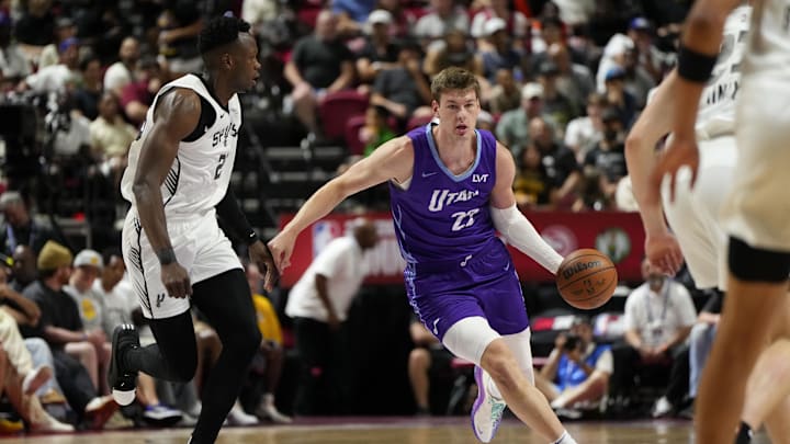 Jul 14, 2025; Las Vegas, NV, USA;  Utah Jazz forward Kyle Filipowski (22) dribbles the ball against San Antonio Spurs forward Osayi Osifo (26) during the first half of a NBA basketball game at Thomas & Mack Center. Mandatory Credit: Lucas Peltier-Imagn Images