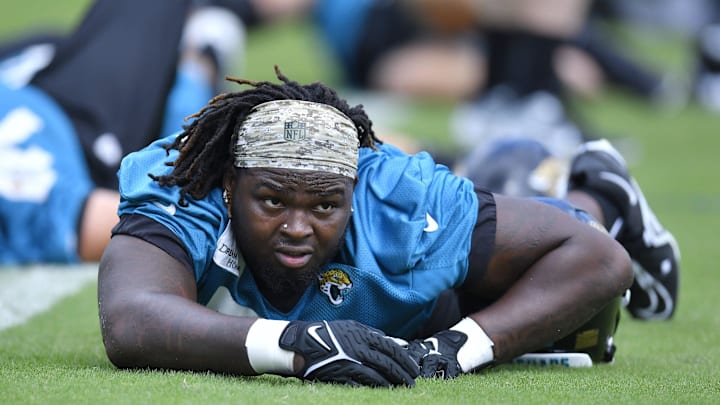 Jacksonville Jaguars offensive tackle Anton Harrison (76) and first round draft pick stretches.