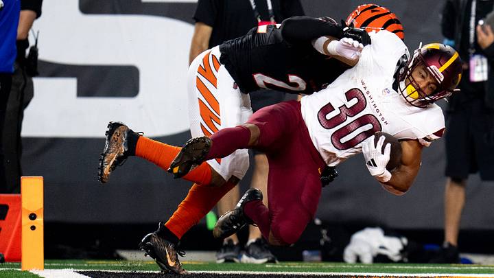 Washington Commanders running back Austin Ekeler (30) scores a touchdown as Cincinnati Bengals safety Geno Stone (22) attempts to stop him in the second quarter of the NFL game at Paycor Stadium in Cincinnati on Monday, Sept. 23, 2024.