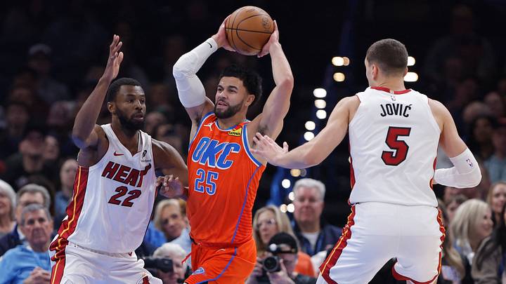Jan 11, 2026; Oklahoma City, Oklahoma, USA; Oklahoma City Thunder guard Ajay Mitchell (25) passes in between Miami Heat forward Andrew Wiggins (22) and forward Nikola Jović (5) during the second quarter at Paycom Center. Mandatory Credit: Alonzo Adams-Imagn Images Jan 11, 2026; Oklahoma City, Oklahoma, USA; Oklahoma City Thunder guard Ajay Mitchell (25) passes in between Miami Heat forward Andrew Wiggins (22) and forward Nikola Jović (5) during the second quarter at Paycom Center. Mandatory Credit: Alonzo Adams-Imagn Images