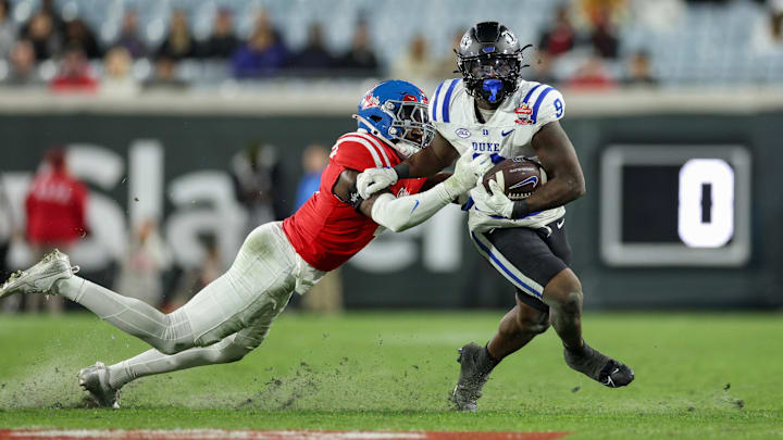 Jan 2, 2025; Jacksonville, FL, USA; Duke Blue Devils running back Jaquez Moore (9) is chased by Mississippi Rebels linebacker Suntarine Perkins (4) in the second quarter during the Gator Bowl at EverBank Stadium. Mandatory Credit: Nathan Ray Seebeck-Imagn Images Jan 2, 2025; Jacksonville, FL, USA; Duke Blue Devils running back Jaquez Moore (9) is chased by Mississippi Rebels linebacker Suntarine Perkins (4) in the second quarter during the Gator Bowl at EverBank Stadium. Mandatory Credit: Nathan Ray Seebeck-Imagn Images