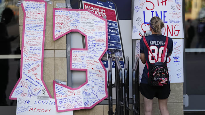Aug 30, 2024; Columbus, OH, USA; Meaghan Little of Columbus leaves a note outside Nationwide Arena at a makeshift memorial for Columbus Blue Jackets forward Johnny Gaudreau. Gaudreau and his brother, Matthew, were killed in a bicycle accident the night before. Mandatory Credit: Adam Cairns/Columbus Dispatch-USA TODAY Network