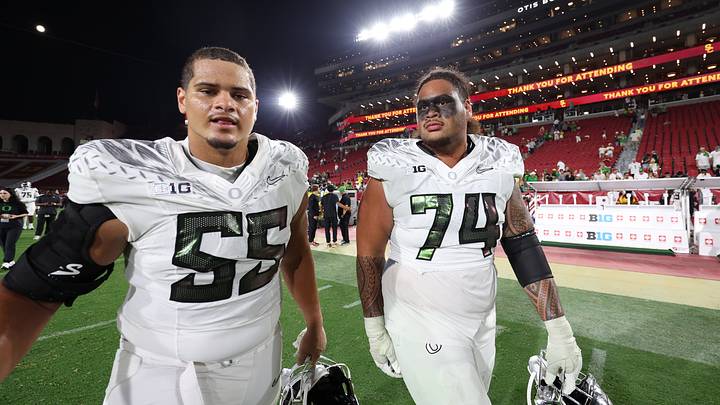 Sep 26, 2026; Los Angeles, California, USA;  Oregon Ducks defensive lineman Matthew Johnson (55) and offensive lineman Dave Iuli (74) walk on the field after a game against the USC Trojans at United Airlines Field at Los Angeles Memorial Coliseum.  Mandatory Credit: Kiyoshi Mio-Imagn Images